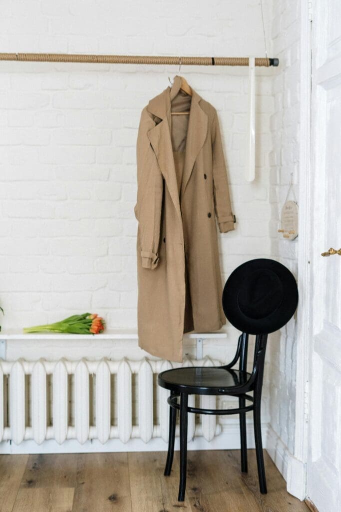 Trench coat hanging in minimal Scandinavian meets California white entry way back drop